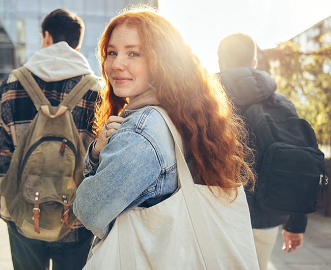NDSU student with red hair walking to class after getting a debt consolidation loan from Gate City Bank in Fargo, ND.
