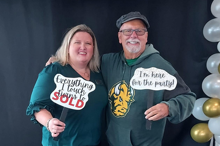 Longtime Gate City Bank customer Mark Rye and his adult niece pose for a picture while holding funny prop signs