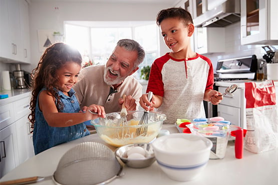 a man watches his grandkids mix ingredients after learning about Roth vs traditional IRAs from Gate City Investment Services