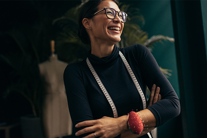 a joyful and confident female business owner looks on and reflects on the benefits of Gate City Bank’s positive pay service