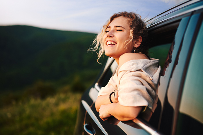 Woman with blonde hair in her car enjoying the sunset after getting her auto loan from Gate City Bank in Alexandria, MN.