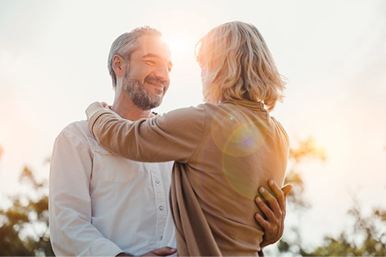 a happy couple embraces outdoors after reading Gate City Investment Services’ 6 tips for retirement planning in your 50s