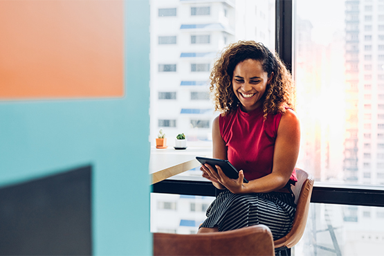 excited businesswoman with complete business checking holds tablet in high rise  office