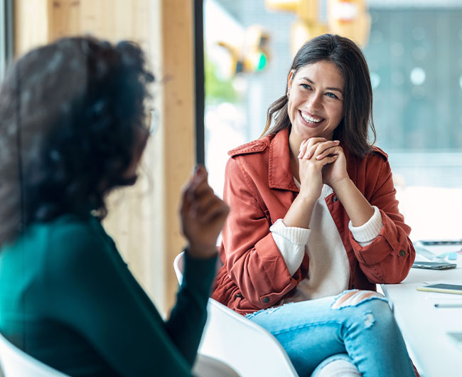 Young woman smiling while talking with a friendly banker at Gate City Bank’s Village West location in Fargo, ND