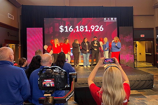 Rape and Abuse Crisis Center representatives react with excitement onstage as Gate City Bank team members and others look on