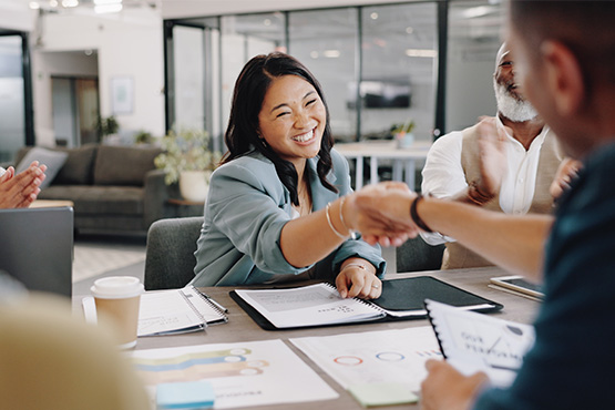 relaxed and happy young woman shaking hands with her local insurance advisor in Fargo, ND