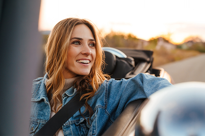woman smiling and driving her new convertible at sunset after getting an auto loan from Gate City Bank in Moorhead, MN