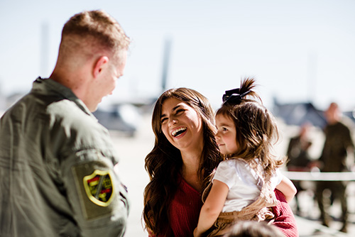 a U.S. service member who qualifies for no documentation fees on Gate City Bank personal loans greets his wife & little girl