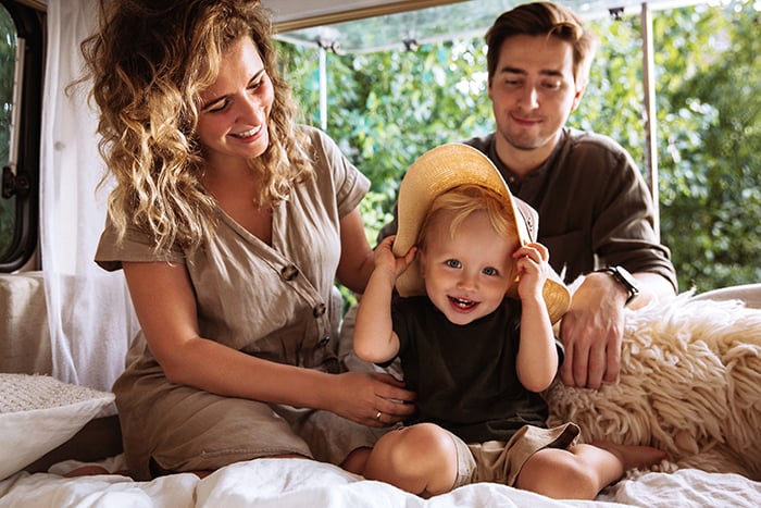 Smiling young parents camping out with their son in a new motorhome, thanks to Gate City Bank’s RV loans