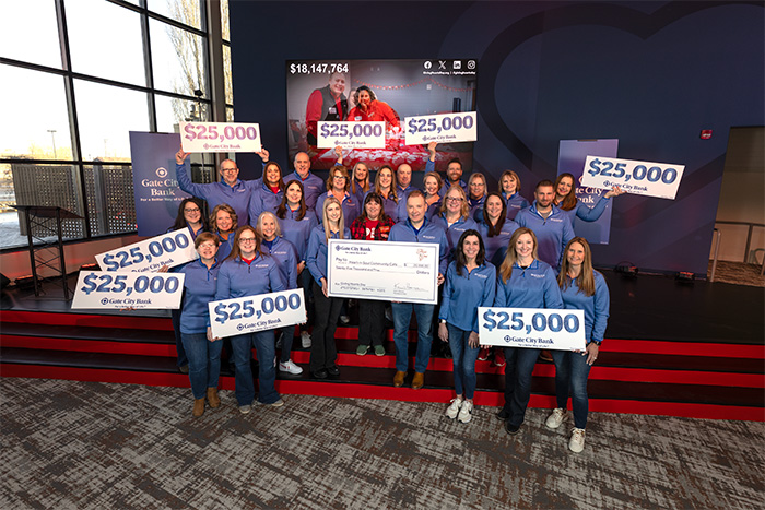 Gate City Bank employees give a large check to Heart-n-Soul Community Café, which won the bank’s Giving Hearts Day nomination contest 