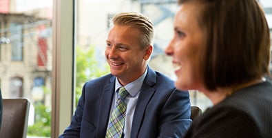 Relaxed businessman in a blue suit, sitting down to chat with a Gate City Bank treasury management consultant in Fargo, ND