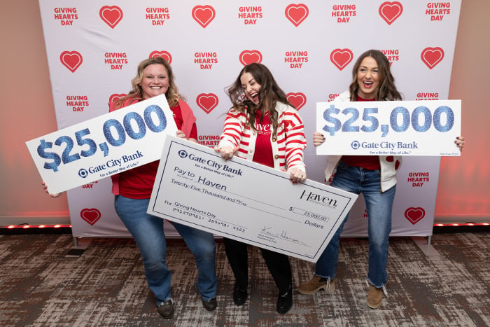 Three excited Giving Hearts Day winners from Haven, celebrating and holding a $25,000 check from Gate City Bank in Fargo, ND