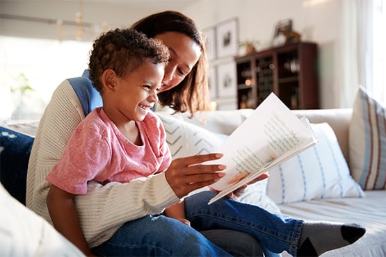 a happy mom reads her son a book after learning tips for retirement planning in your 30s from Gate City Investment Services