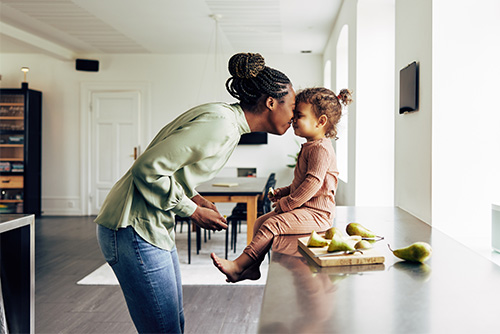 a mother and young daughter happily nuzzle noses in their new house after securing a home loan from Gate City Bank