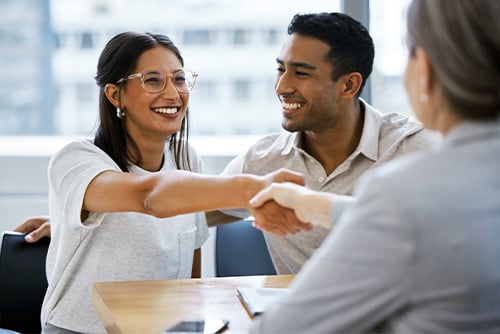 a happy couple chats with an advisor after learning about ways to cut home insurance costs from Gate City Insurance Agency