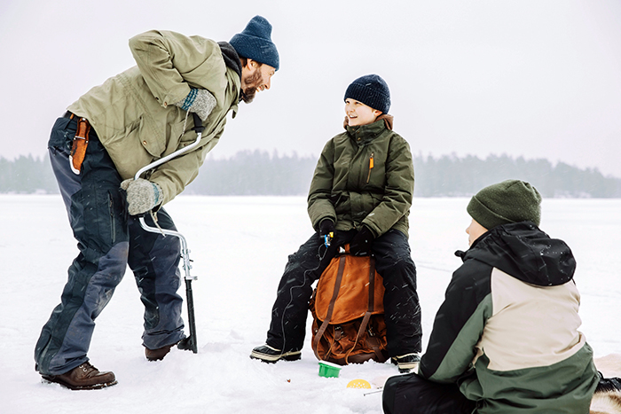 Dad and his two sons ice fishing on Pelican Lake in Minnesota thanks to Gate City Bank's no payment for 120 days promotion.