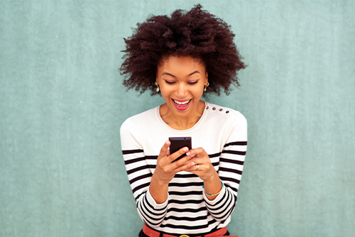 excited young woman checks smartphone after opening a checking reserve line of credit at Gate City Bank