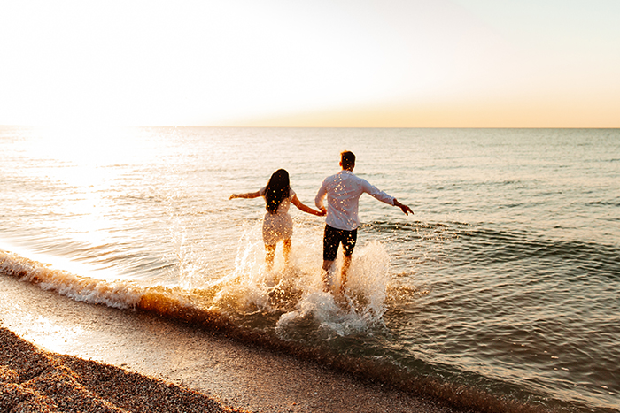 Couple walking on a beach after winning a vacation just by using their Gate City Bank debit card through mobile wallet