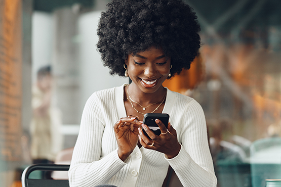 a smiling woman uses her phone to learn about Gate City Bank’s enhanced digital experience for personal and business banking