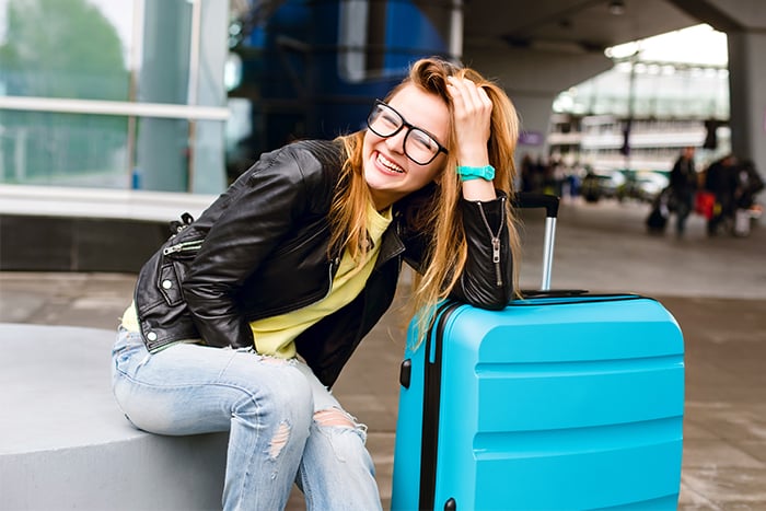 Young girl with her suitcase, ready to travel using her debit card rewards.