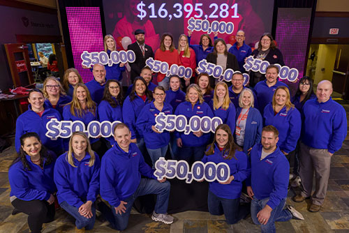 Happy group from Gate City Bank holding “$50,000” signs on Giving Hearts Day