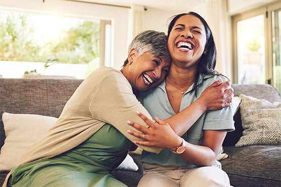 an adult daughter hugs her mother after learning about steps to pursue early retirement from Gate City Investment Services