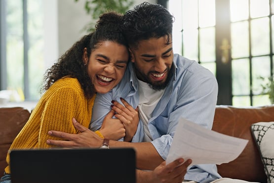 Gen Z first-time homeowners hug in celebration of finding a mortgage loan term that works for them.